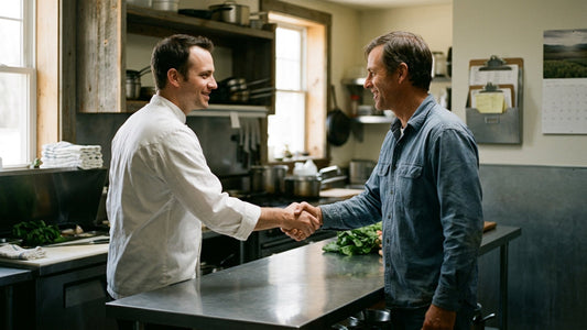 Farmer and chef shaking hands in a restaurant kitchen